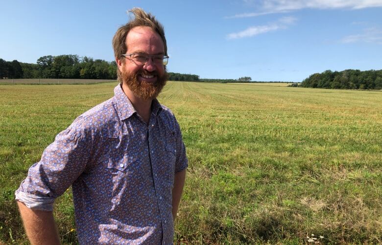 A man stands in a farm field.