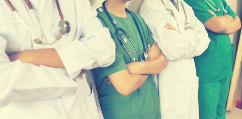 A row of people wearing stethoscopes and scrubs.