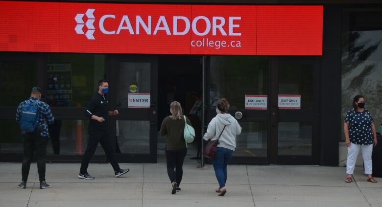 The front of a large building with a red sign that says Canadore College.