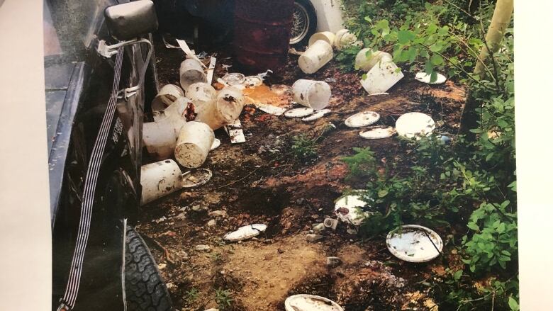 White plastic buckets and lids scattered on the ground. 