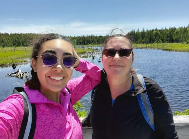 A selfie of two women with a lake in the background