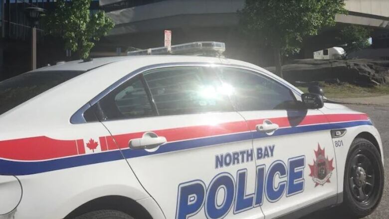 Sunlight glints off the passenger window of an unoccupied North Bay Police cruiser.