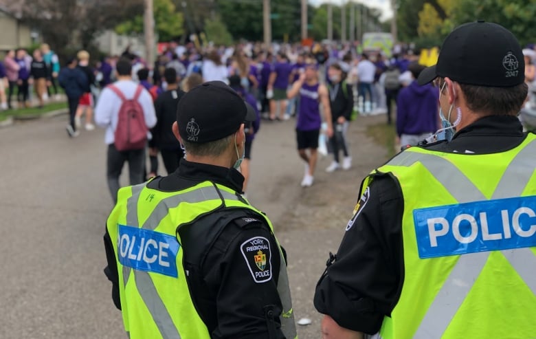 police officers watching students at a street party