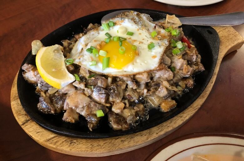 A dish filled with meat topped with a friend egg.