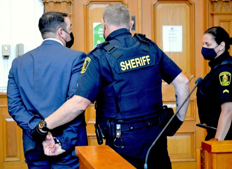 Man with handcuffs led by sherriff