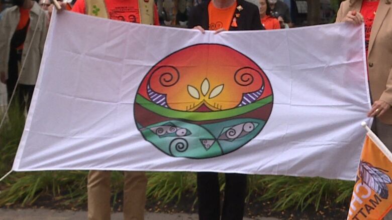 Three people hold a flag.