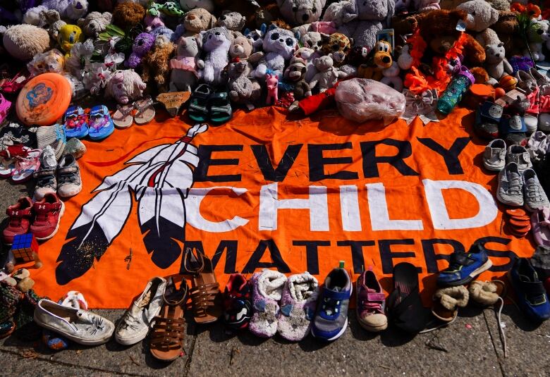 An orange sign is spread out on the ground. It reads 