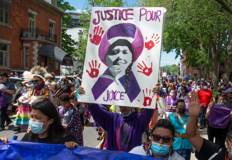 Protesters hold up a sign that reads 'Justice for Joyce.'