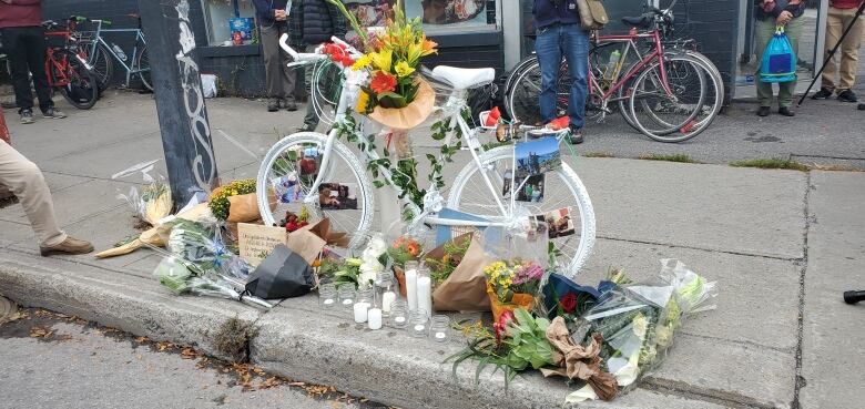 A bike painted white and adorned with flowers. 