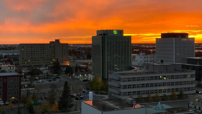 A city skyline and a setting sun.