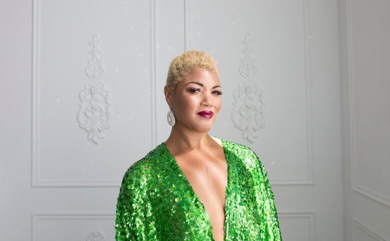 A Black woman with blonde hair wearing a green dress