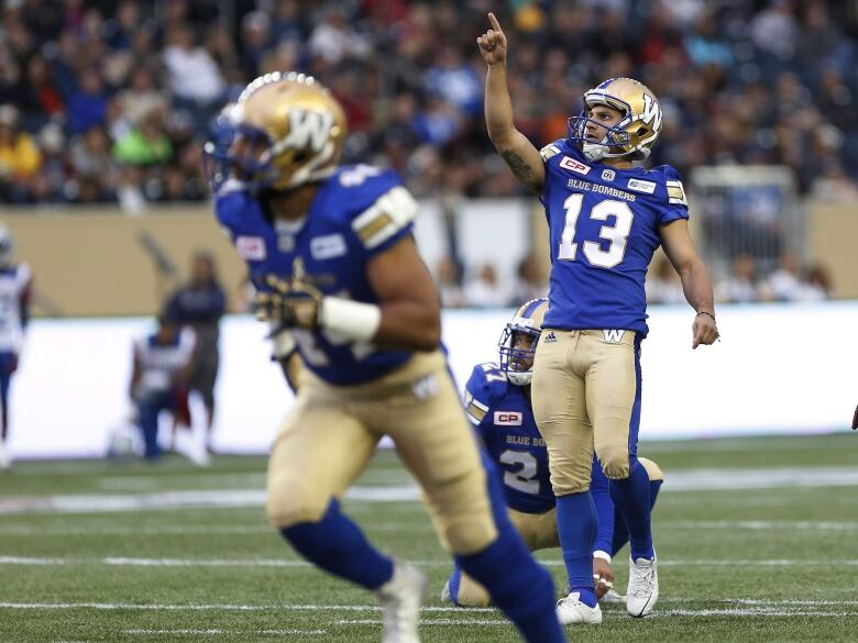 A kicker points to the sky after a kick.