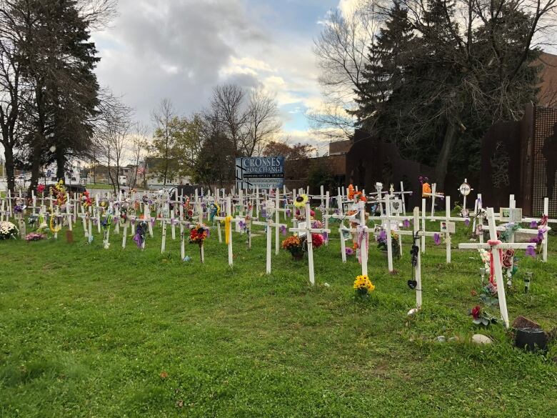 Several rows of white crosses with flowers.