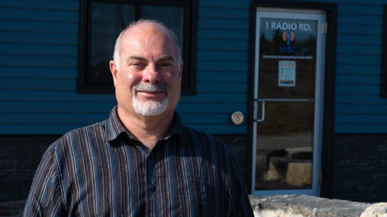 A man stands outside a radio station building.