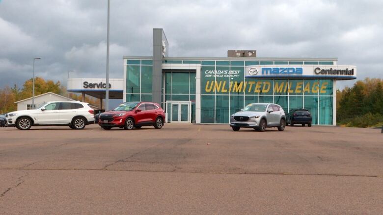 Large parking lot with three vehicles in it.