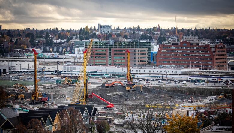 A vast construction site is seen against the backdrop of the city of Vancouver. 