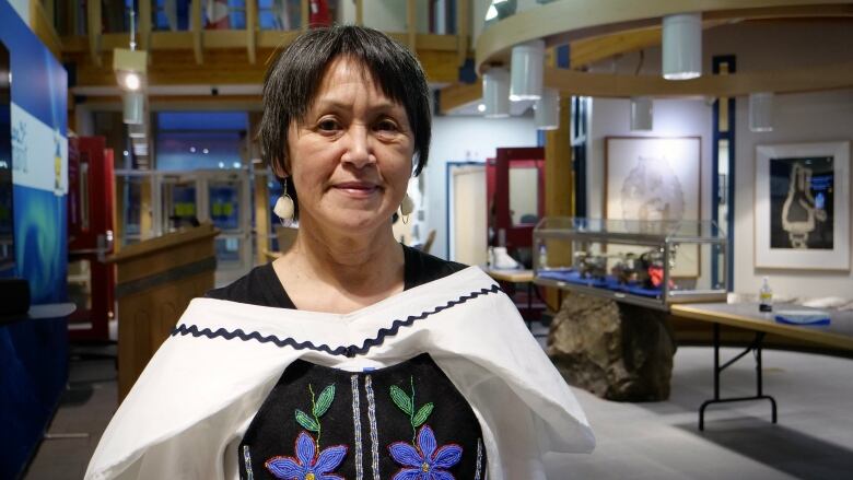 A woman poses for a photo inside a government building.