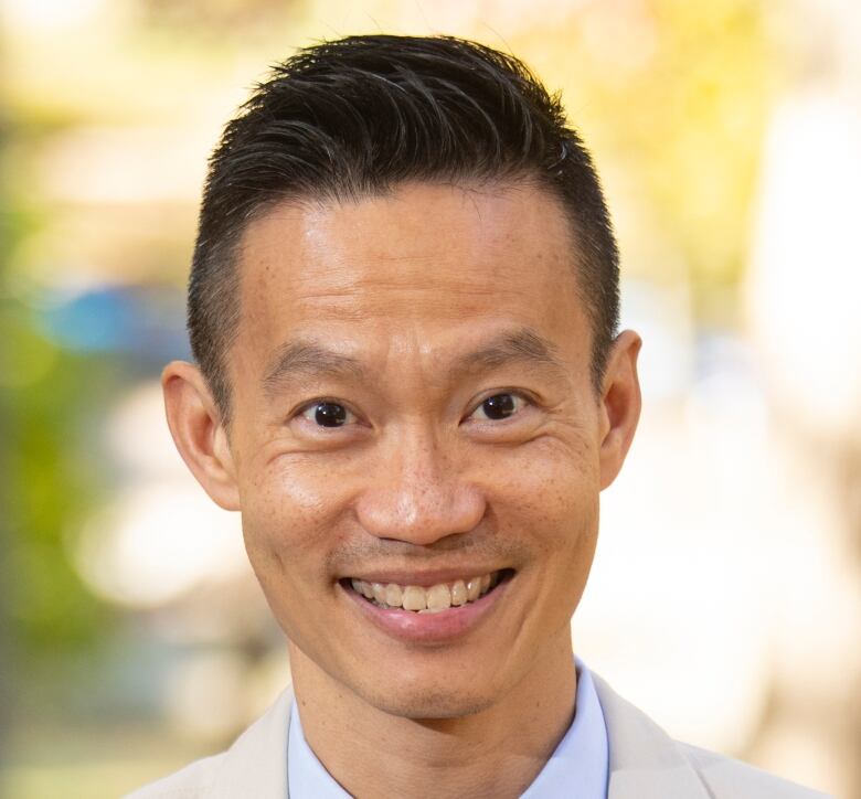 An Asian man wearing a cream suit