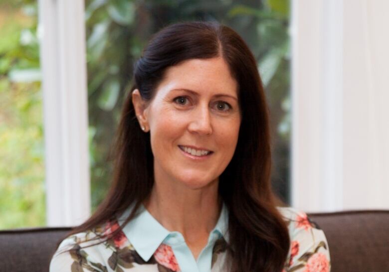 A white woman wearing a floral shirt