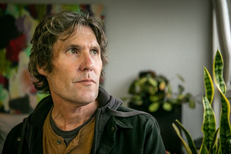 A profile photo of a man, surrounded by plants. 