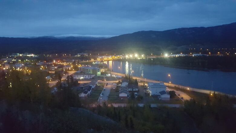 A small city by a river at night.