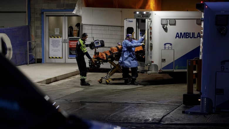 Ambulance paramedics unload a patient.