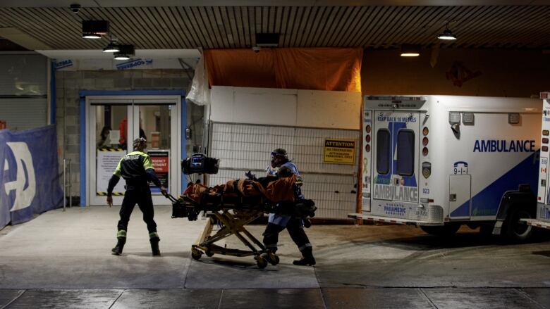 Ambulance paramedics unload a patient at the emergency department of St. Michaels Hospital, in downtown Toronto, on Jan. 4, 2022. 