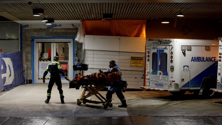 Ambulance paramedics unload a patient at the emergency department of St. Michaels Hospital, in downtown Toronto, on Jan. 4, 2022. 