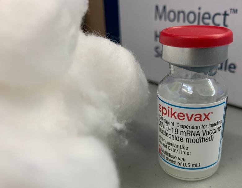 A vial of Moderna vaccine and some cotton balls.