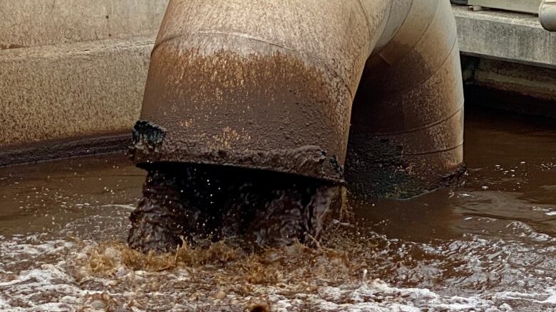 A pipe pumping brown water