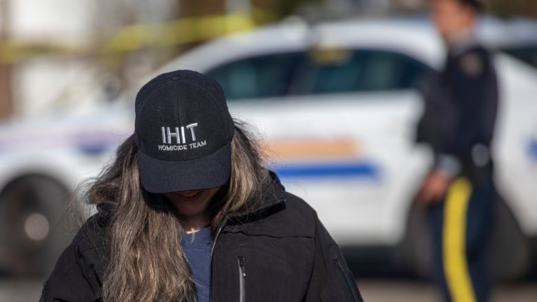 A police officer with a hat that reads 'IHIT Homicide Team'.