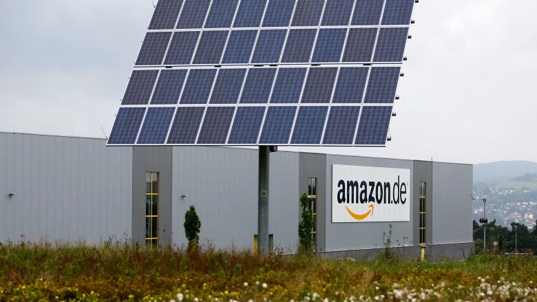 A large solar panel attached to the roof a warehouse with a sign that reads: 