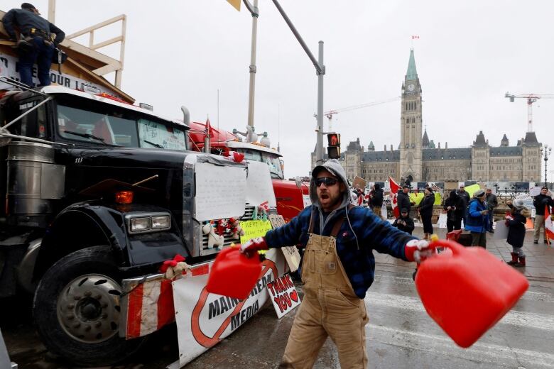 A demonstrator screams and bangs gas canisters together during the ongoing protest in Ottawa Feb. 10, 2022.