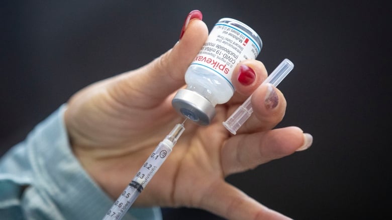 A person draws out a Moderna dose during a drive-through COVID-19 vaccine clinic at St. Lawrence College in Kingston, Ont. 