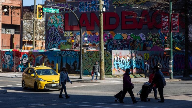 An outdoor space is seen covered by graffiti on a busy street.