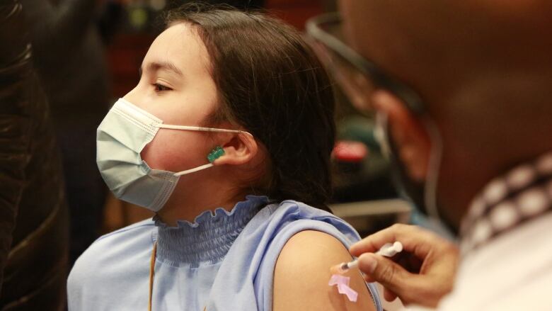 A child receives a Covid-19 vaccine in Winnipeg. A slow uptake by children under 12 in many provinces has health officials concerned about the immunization rate.