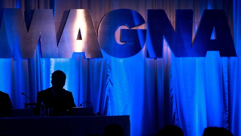 A metallic silver sign with word magna is displayed under a light.