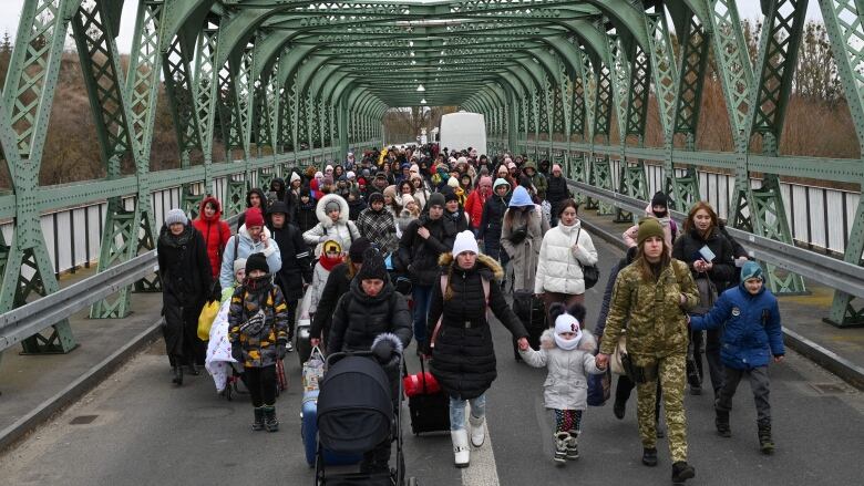 People walk across a bridge.