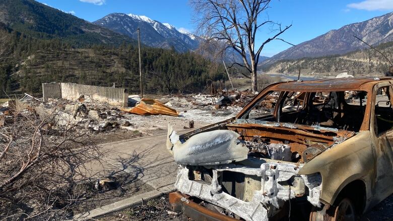 A burned out vehicle and rubble.