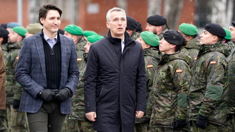 Prime Minister Justin Trudeau, left, and NATO Secretary General Jens Stoltenberg walk during their visit to Adazi Military base in Kadaga, Latvia, Tuesday, March. 8, 2022.