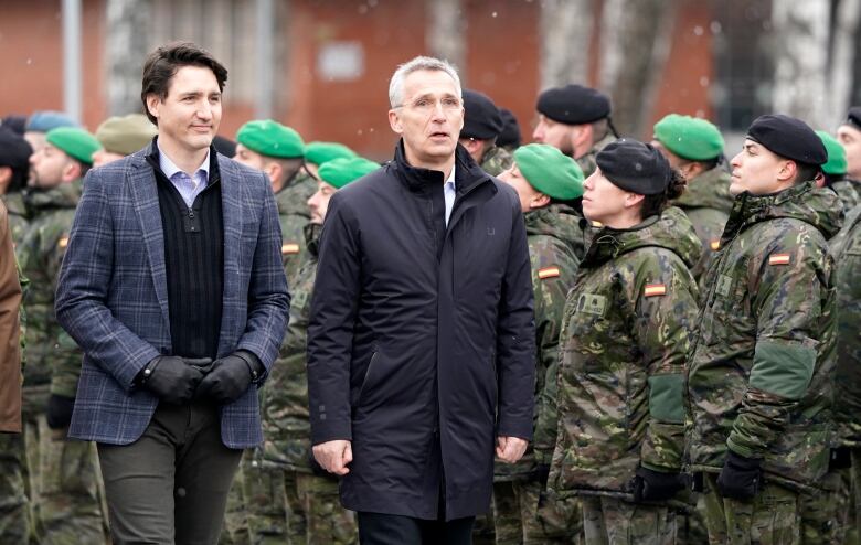 Prime Minister Justin Trudeau, left, and NATO Secretary General Jens Stoltenberg walk during their visit to Adazi Military base in Kadaga, Latvia, Tuesday, March. 8, 2022.