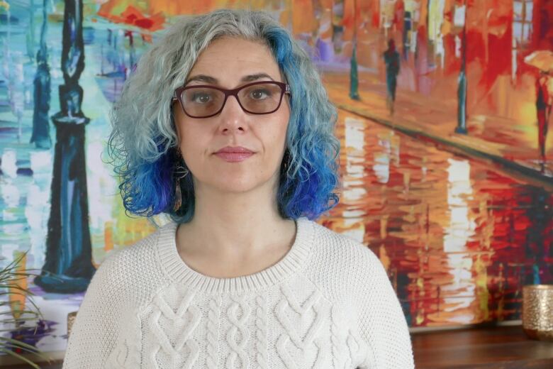 Portrait of a woman in front of artwork.