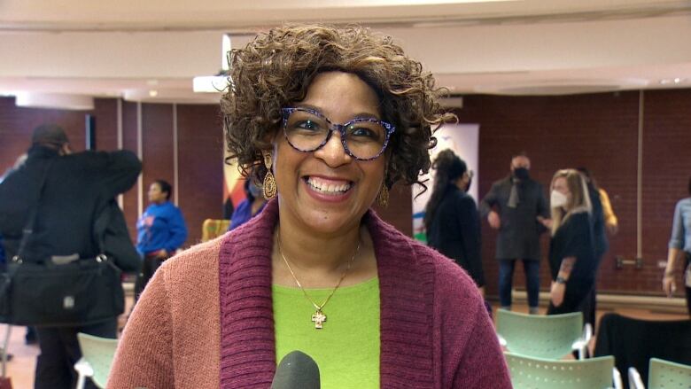 A woman wearing glasses smiles for the camera.