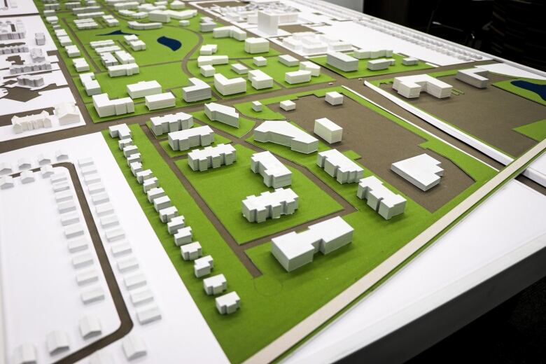 A 3D model is laid out on a table, showing plans for a large development.