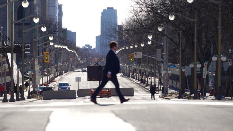 A pedestrian crosses Wellington Street near Parliament Hill in downtown Ottawa.