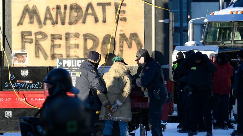 In this file February 2022 photo, RCMP officers take a protester into custody at the Ottawa anti-vaccine mandate protest.