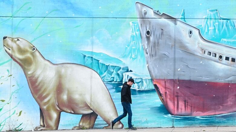 A person walks past a climate change-themed nature mural on Earth Day during the COVID-19 pandemic in Toronto on Thursday, April 22, 2021. Nathan Denette/The Canadian Press