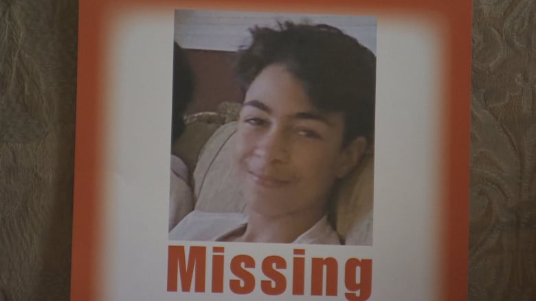 A photo of a boy is seen on a missing person poster.