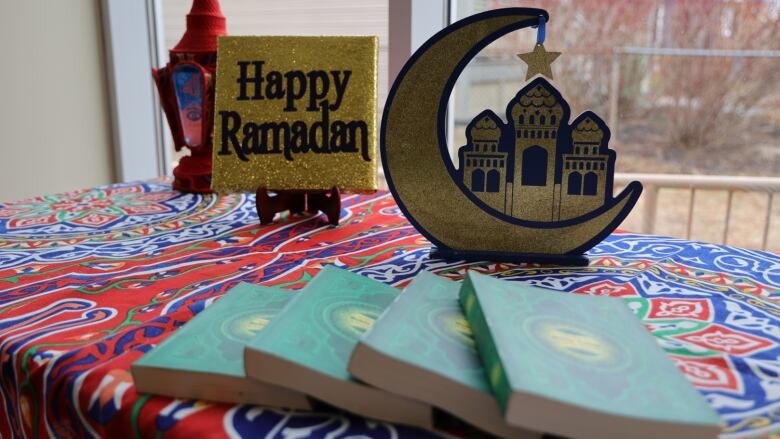 A Ramadan display with a sign and a cutout crescent moon and a mosque.