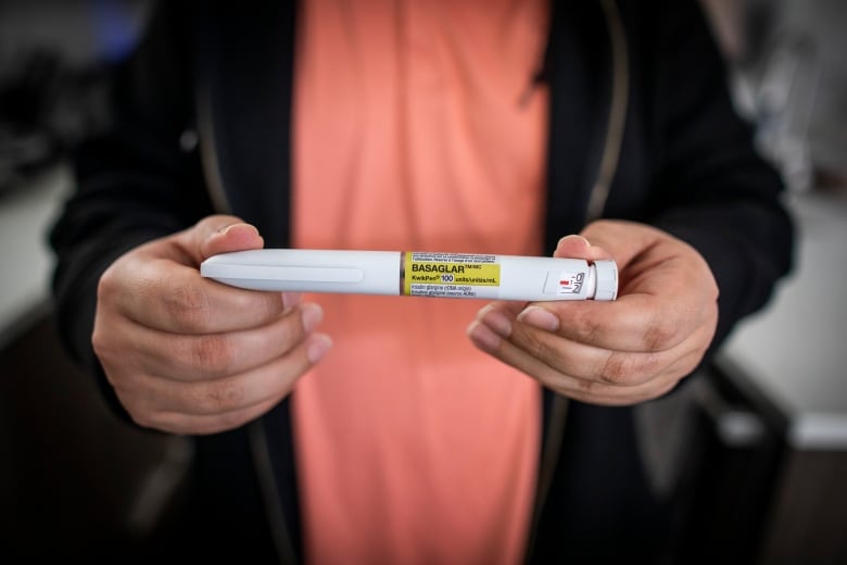 A person holds up an insulin pen.